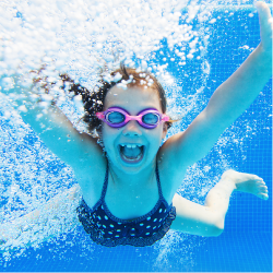 Child underwater smiling.